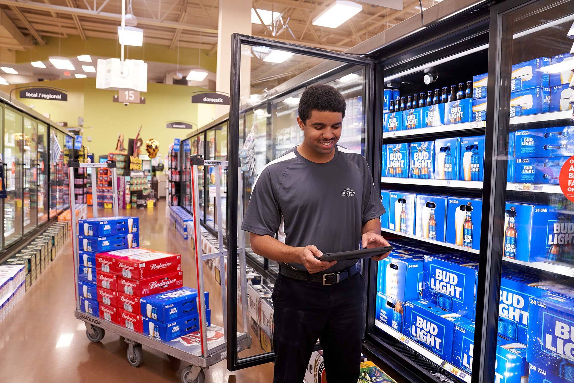 Brown Distributing worker keeping track of all products in grocery store